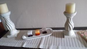 a table with two candles and a remote control at Ey-Giann in Karpenision