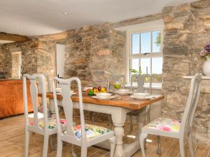 ein Esszimmer mit einem Holztisch und Stühlen in der Unterkunft Bwlchgroes in Dinas