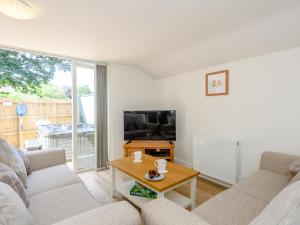 a living room with two couches and a tv at The Chicken Coop in Fulletby