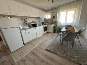 a kitchen with a table and a white refrigerator at Apartament Hanna - Straja in Uricani