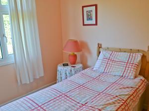 a bedroom with a bed and a lamp on a table at Rowan Cottage-80119 in Catcleugh