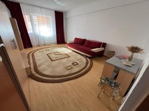 a living room with a red couch and a rug at Apartament Hanna - Straja in Uricani