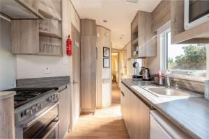 a kitchen with a sink and a stove at 3 Bedroom Caravan-Seton Sands in Port Seton
