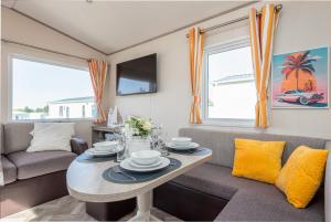 a living room with a table and a couch at 3 Bedroom Caravan-Seton Sands in Port Seton