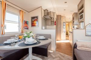 a kitchen and living room with a table in a caravan at 3 Bedroom Caravan-Seton Sands in Port Seton +18 photos