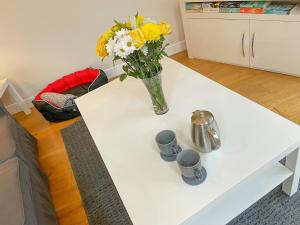 a white coffee table with a vase of flowers on it at Woodside Retreat, Number 37 in Worthington +16 photos