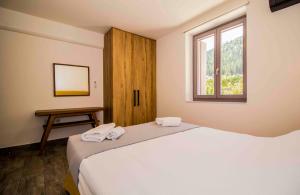 a bedroom with a bed and a window and a table at Mystras 2 Residences Upper and Ground Floor in Mystras