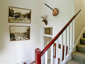 格伦科伦科小屋乡村别墅的墙上有两张照片和时钟的楼梯