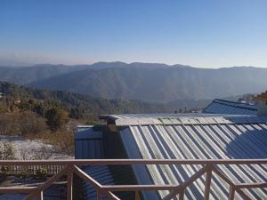 eine Gruppe von Gebäuden mit Bergen im Hintergrund in der Unterkunft Sky touch cottage & stays in Mukteswar