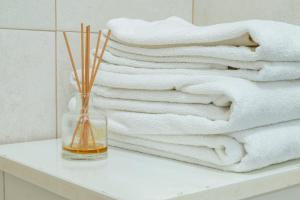 a glass vase sitting on a table with towels at Na Casa da Fátima in Vila Nova de Milfontes +27 photos