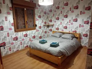 a bedroom with a bed with a wall covered in stickers at Gîte du Tronquoy in Aix-en-Ergny