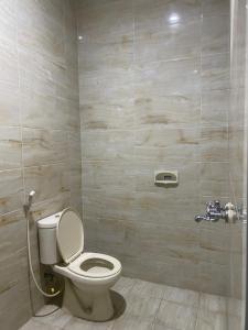 a bathroom with a toilet and a shower at Kalakoala by Zzz in Malang