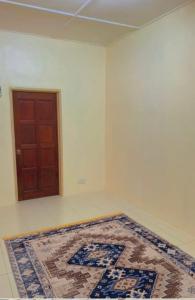 a room with a rug on the floor and a door at Coach homestay 2 in Kuantan +3 photos