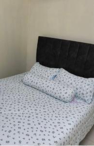 a bed with a black and white comforter and a pillow at Coach homestay 2 in Kuantan