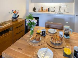 a table with plates of food on it in a kitchen at The Sail Loft - Royal William Yard in Millbrook +32 photos