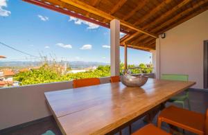 a wooden table with chairs and a large window at Mystras 2 Residences Upper and Ground Floor in Mystras