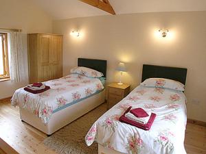 FilbyにあるThe Stablesのベッドルーム1室(赤い靴を履いたベッド2台付)