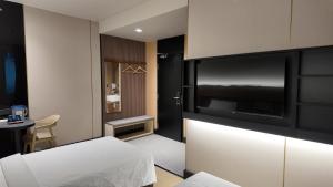 チャンルーンにあるUrban Inn, Changlunのベッドとテレビがあるホテルの部屋