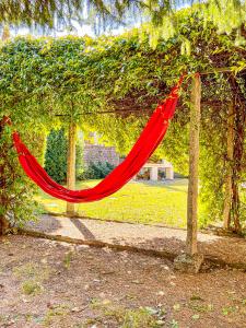 a red hammock hanging from a tree in a park at Casa Tranquilla in Cannobio