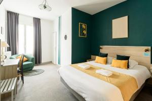 a bedroom with a large bed and a green wall at Cit' Hotel de France in Rochefort