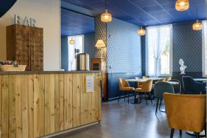 a restaurant with a bar and tables and chairs at Cit' Hotel de France in Rochefort