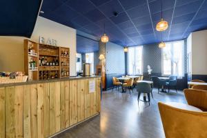 een restaurant met een bar en tafels en stoelen bij Cit' Hotel de France in Rochefort
