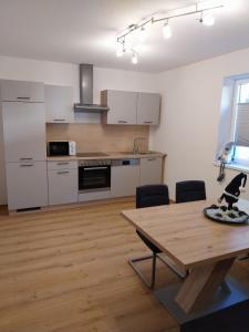 eine Küche mit Holztisch und Holzboden in der Unterkunft Ferienwohnung Büchele in Umhausen