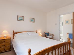 ein Schlafzimmer mit einem großen weißen Bett und ein Badezimmer in der Unterkunft Berrystead Upper Flat in Salcombe