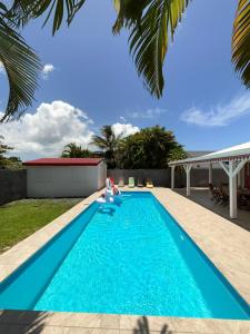 a swimming pool with blue water in a backyard at Villa Loma in Sainte-Rose