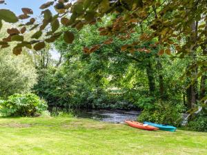 two kayaks sitting on the grass next to a river at Mountain View in Llawhaden