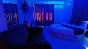 a living room with blue lighting and a couch at Smooth Checkin By Edition Blue - Mumbai in Mumbai