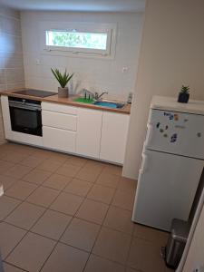 a kitchen with a white refrigerator and a sink at gîte vacances in Moncontour +19 photos