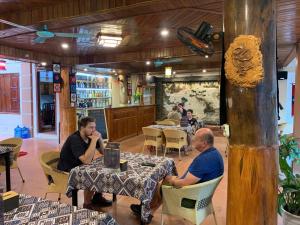 a group of people sitting at tables in a restaurant at Mai Chau Hostel in Mai Châu