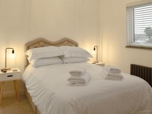 a bedroom with a white bed with towels on it at Little Trevose in Padstow +9 photos