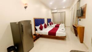 a bedroom with a bed and a refrigerator in it at Smooth Checkin By Edition Blue - Mumbai in Mumbai +33 photos