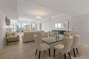 een eetkamer en woonkamer met een tafel en stoelen bij Chic Three-Bedroom Oceanfront Apartment with Stunning Views in South Palm Beach