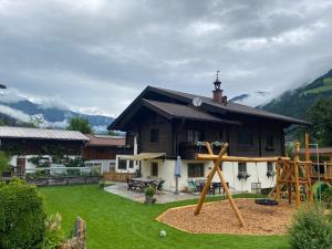 a large house with a playground in the yard at Bio Bauernhof Schweizerhof in Bad Hofgastein