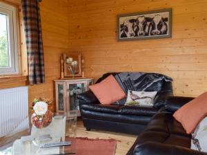 a living room with a leather couch and a table at Pheasant Lodge - Uk33402 in Hungerton