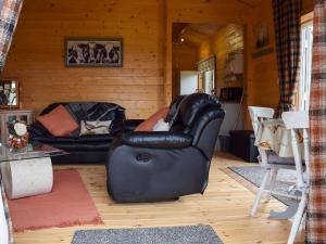 a living room with two leather chairs in a cabin at Pheasant Lodge - Uk33402 in Hungerton