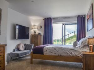 een slaapkamer met een bed, een tv en een raam bij Seascape in Sandown +14 foto's
