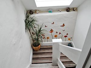 ein Flur mit einer Pflanze und Schmetterlingen an der Wand in der Unterkunft The Little Stone Cottage in Loftus