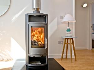 a fireplace with a fire in a living room at Una Argentum 61 in Carbis Bay