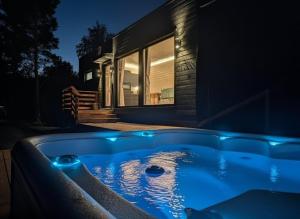 a hot tub in front of a house at night at Spa Cabin by Hossaville in Hossa