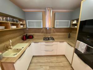 a small kitchen with white cabinets and a sink at Apartmán u Kuľky in Spišské Bystré
