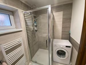 uma pequena casa de banho com uma máquina de lavar roupa e uma máquina de lavar roupa em Apartmán u Kuľky em Spišské Bystré mais 8 fotografias