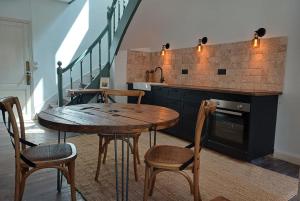 エイメにあるLa Belle Courのキッチン(木製のテーブル、椅子、シンク付)