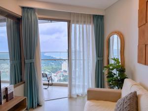een woonkamer met een bank en een groot raam bij The Sóng Apartment - Habi's Home in Vung Tau