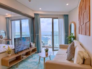 een woonkamer met een bank en een flatscreen-tv bij The Sóng Apartment - Habi's Home in Vung Tau