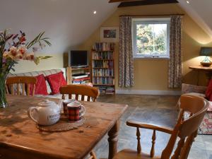 a living room with a wooden table and chairs at Fairlaw Garden Cottage in Reston