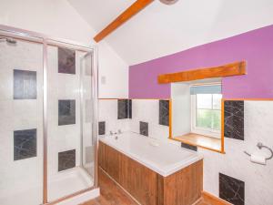a bathroom with a tub and a shower at Cwm Nantcol Barn in Llanbedr +3 photos